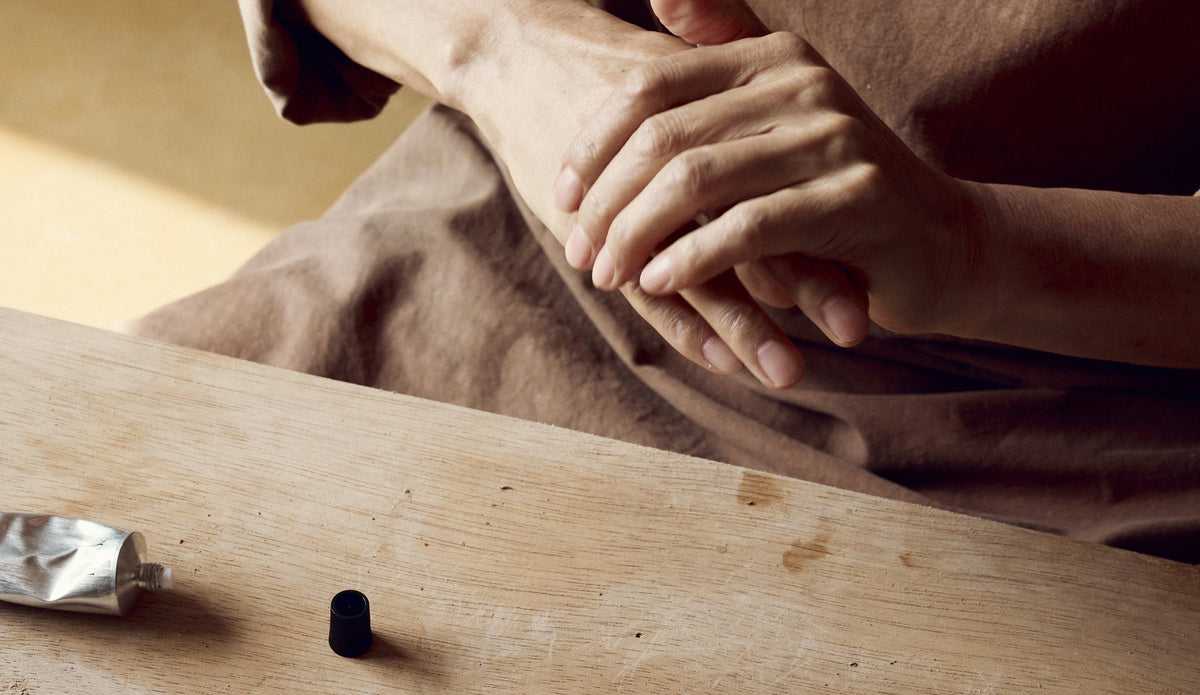 Gentle hand massage with natural skincare, wooden table, silver tube, mindful self-care ritual