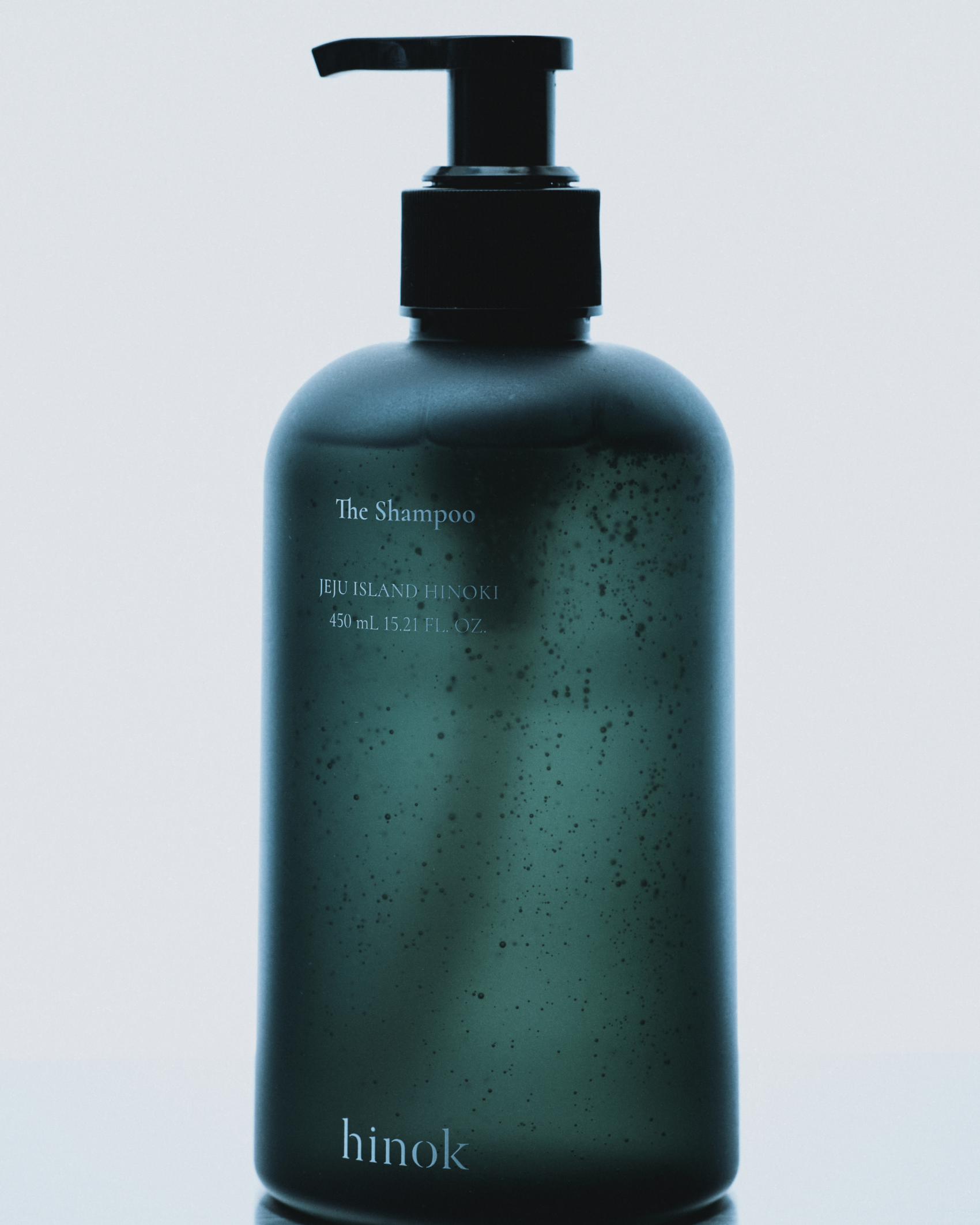 The Shampoo pump bottle on a pale studio background